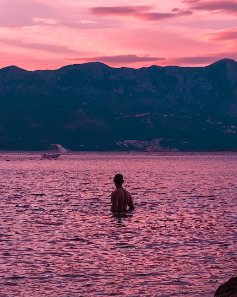 Auf diesem Bild ist ein Mann zu sehen, der an der Küste von Montenegro im Meer badet 